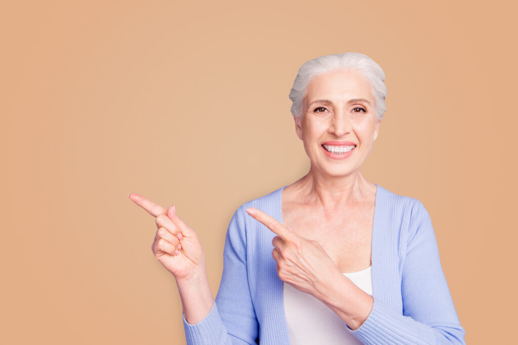 Smiling person pointing with both fingers towards to right